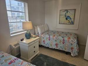 Room 22 bedroom with 2 double beds and fish-themed quilts
