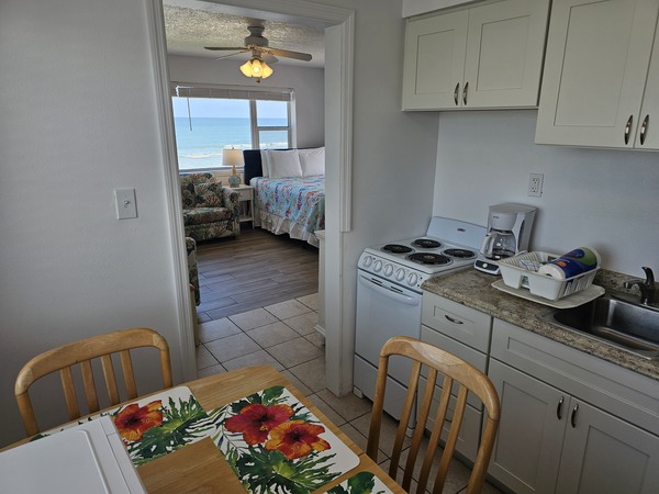 Room 32 kitchen table, chairs, stove, view into living room