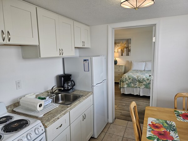 Room 29 kitchen looking toward bedroom, kitchen cabinets, table